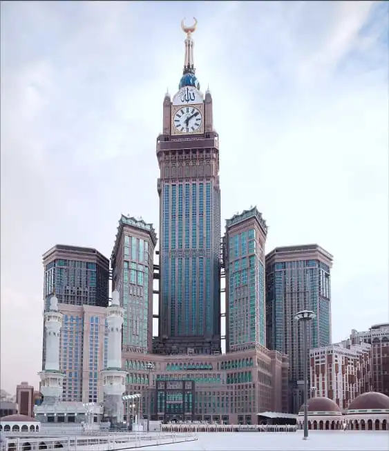 A low-angle view of the Abraj Al Bait clock tower and surrounding skyscrapers from the courtyard of Al-Masjid Al-Haram.
