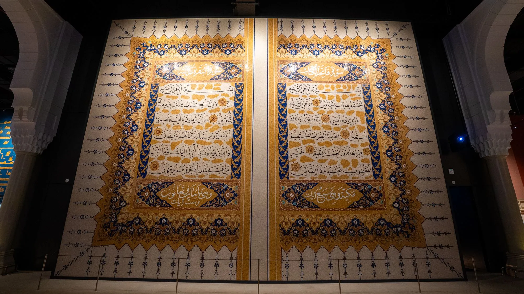 A massive illuminated mural of the opening chapters of the Quran at The Holy Quran Exhibition in Makkah.