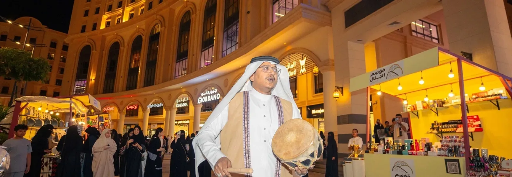 رجل يرتدي رداءً أبيض يحمل طبلاً