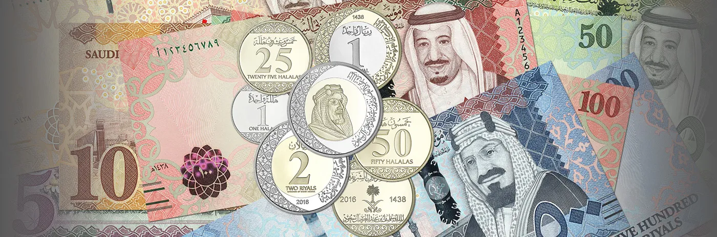 A collection of Saudi Arabian Riyal banknotes and coins, representing local currency and payment methods.
