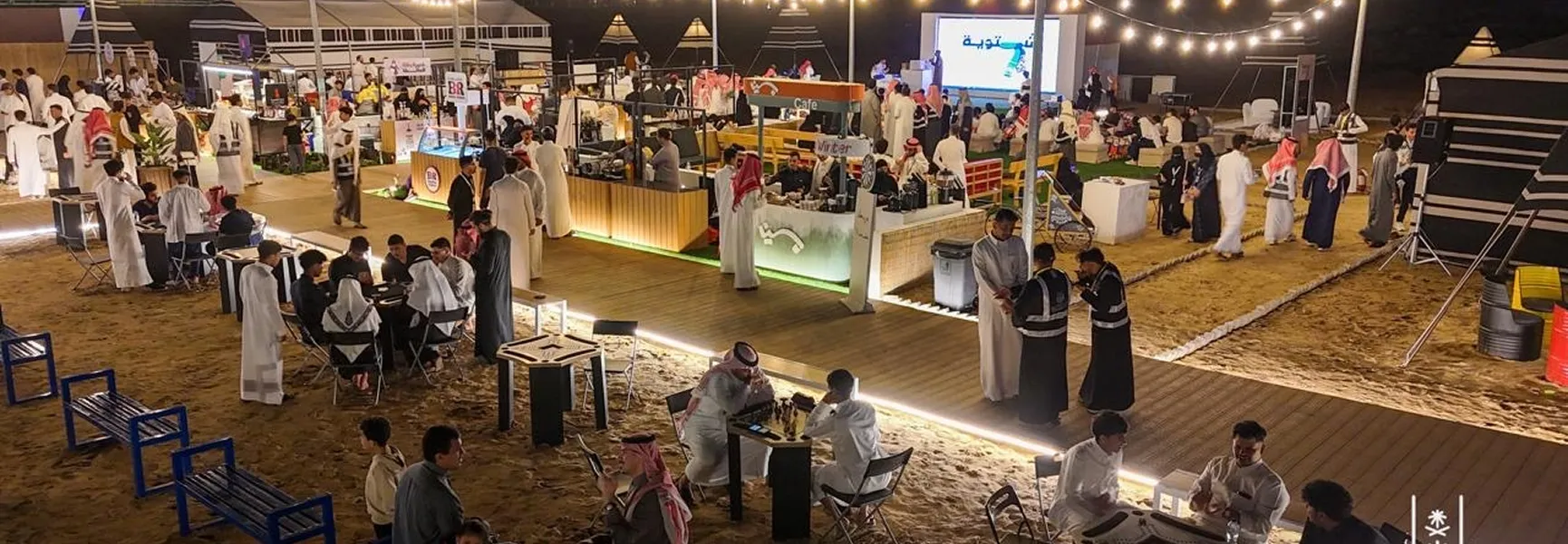 مجموعة من الأشخاص يرتدون عباءات بيضاء على الشاطئ