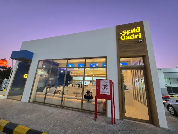 The modern storefront of Gadri restaurant in Makkah with illuminated signage during twilight.