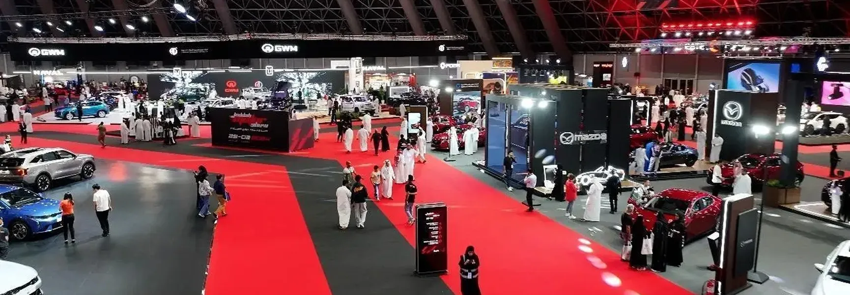 مجموعة من الأشخاص في غرفة كبيرة بسجادة حمراء